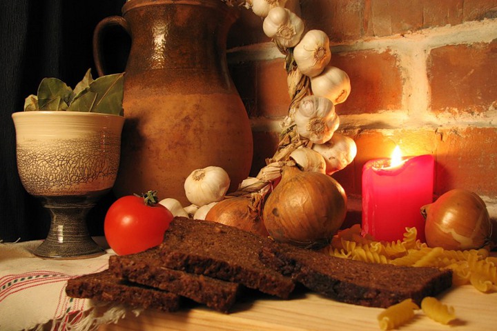 leipää, sipulia ja kynttilää pöydällä