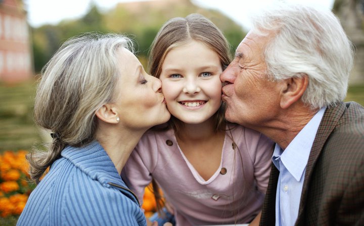 grands-parents embrassent petite-fille