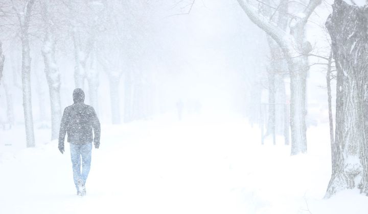 A man walks through a snowy park